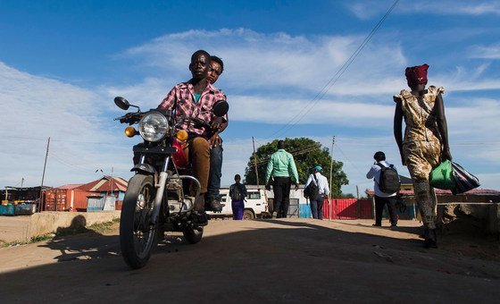 Des personnes à moto et à pied sur une route au Soudan du Sud, près de la mission de l'ONU au Soudan du Sud (MINUSS)